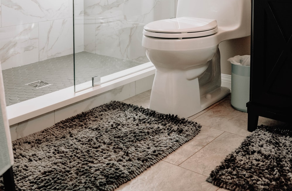 A bathroom with rugs.