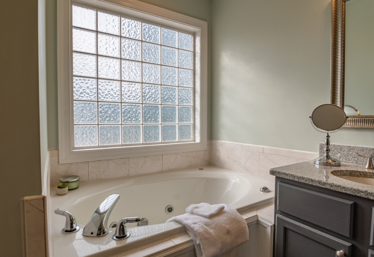  A white ceramic bathtub with a towel